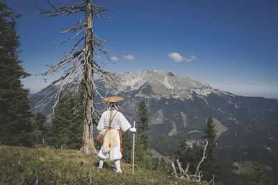 Man standing on field against mountain range