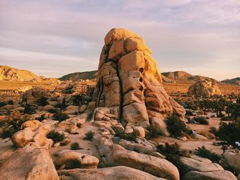 Rock formations on landscape against cloudy sky