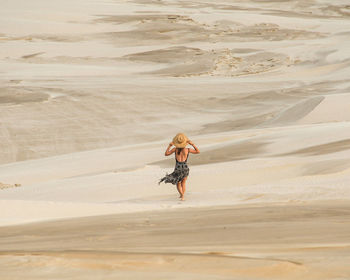 Rear view of woman walking on beach