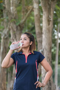 Full length of a beautiful young woman drinking glass