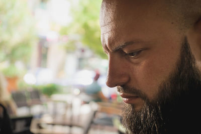 Close-up portrait of young man looking away outdoors