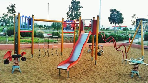 Empty swing in park against sky