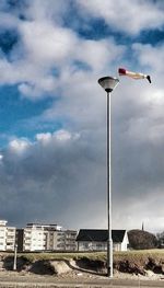 Street light against cloudy sky