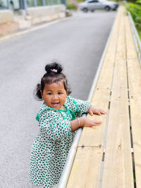 Portrait of cute girl standing on footpath