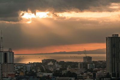 View of cityscape against cloudy sky during sunset