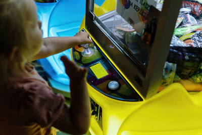 Little girl playing arcade game at night