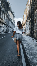 Rear view of woman standing on road