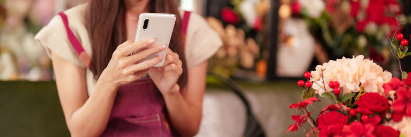 Midsection of woman using mobile phone