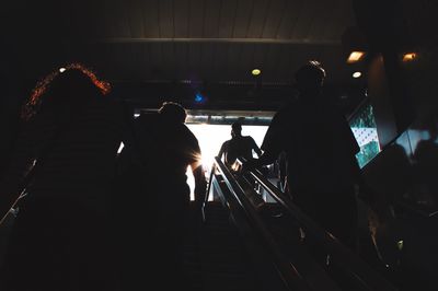 Rear view of silhouette people standing on steps