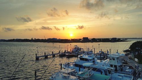 Boats in sea at sunset