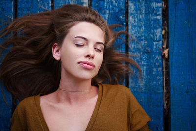 High angle view of beautiful young woman lying on wood paneling
