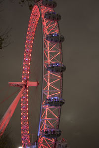 Low angle view of illuminated ferris wheel against sky at night