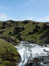 Scenic view of waterfall against sky