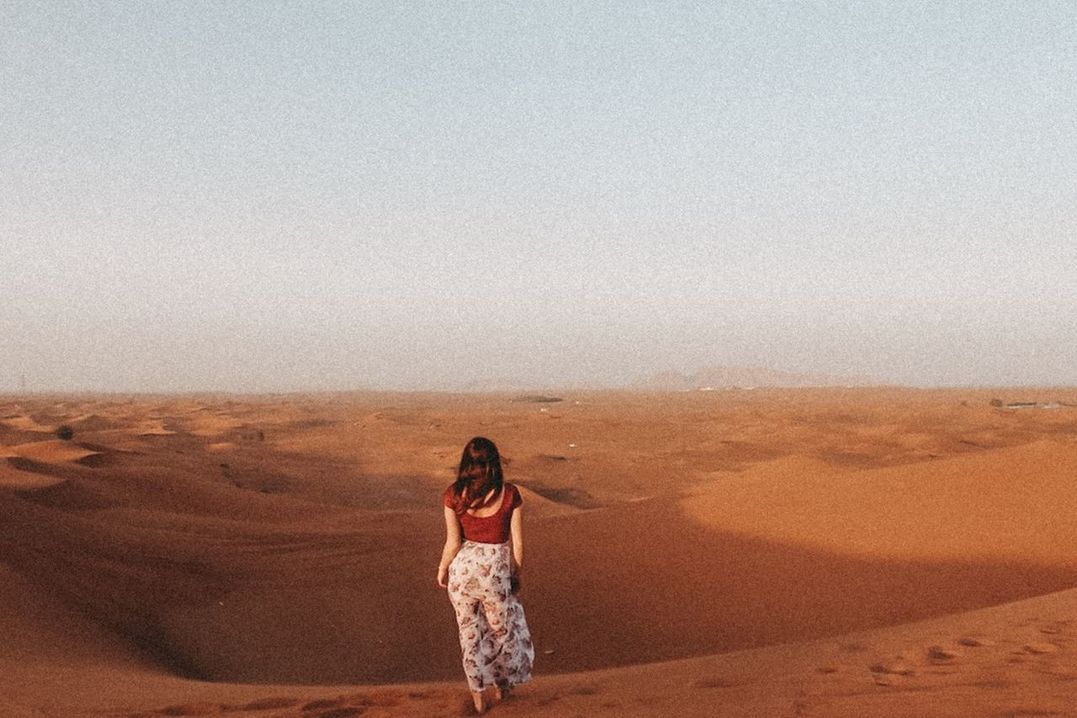 FULL LENGTH OF YOUNG WOMAN STANDING ON DESERT LAND