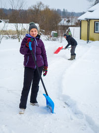 Senior man cleaning snow on street