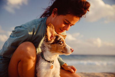 Woman with dog at beach against sky