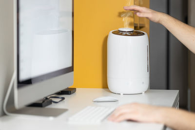 White air humidifier spreading steam. humidification of dry air while man working on computer. 