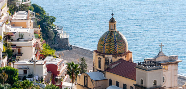 High angle view of townscape by sea against buildings