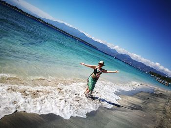 Man standing on beach against clear blue sky