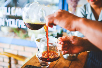 Midsection of woman drinking glass in wineglass