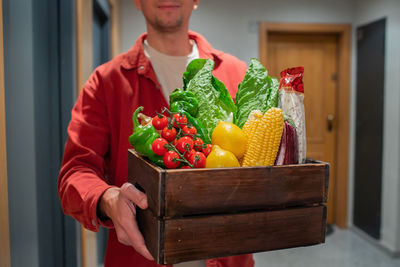 Midsection of woman holding fruits on table