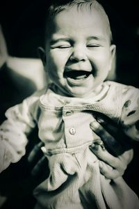 Close-up of parent holding cheerful baby