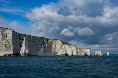 Sea by cliff against sky