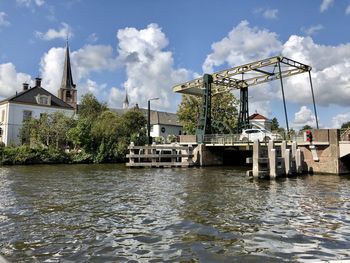 Scenic view of river by building against sky