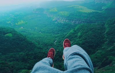 Low section of woman relaxing on landscape
