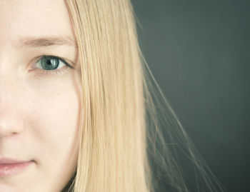 Close-up portrait of beautiful young woman over colored background