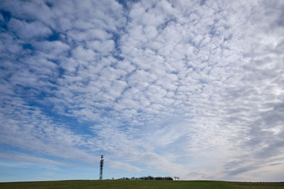 Low angle view of windmill on field against sky