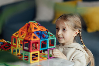 Cute girl playing with toy blocks