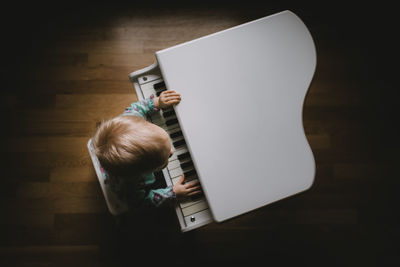 High angle view of boy playing piano