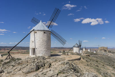 Traditional windmill on field against sky