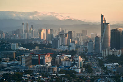 High angle view of modern buildings in city against sky during sunset