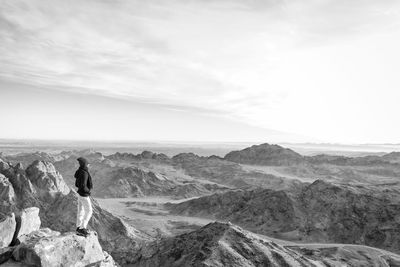 Man looking at mountains against sky