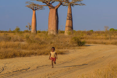 Full length of man standing on landscape against clear sky