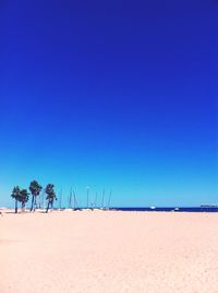 Scenic view of beach against clear blue sky