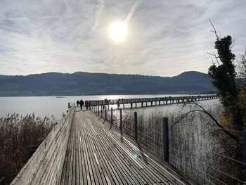 Pier over lake against sky