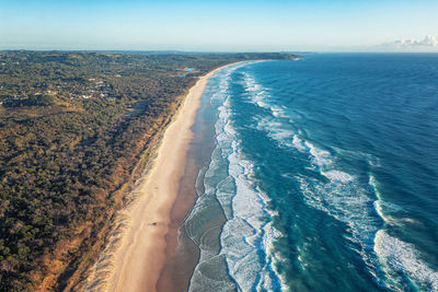 Greatness of the turquoise sea. foamy ocean waves roll and approach sandy beach. travel concept.