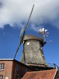 Low angle view of traditional windmill against sky