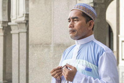 Man praying while standing in mosque