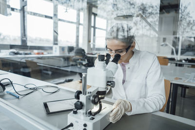 Young scientist working on microscope in laboratory