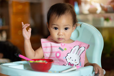 Portrait of cute baby girl on table