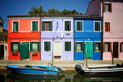 Multi colored boats moored against clear blue sky