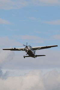 Low angle view of airplane flying against sky