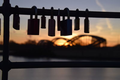 Close-up of padlocks on railing against sky