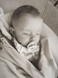 Baby boy with pacifier in mouth at home