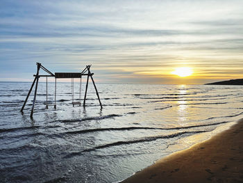 Scenic view of beach against sky during sunset