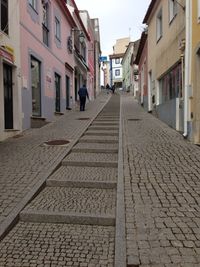 Woman walking on cobblestone street in city